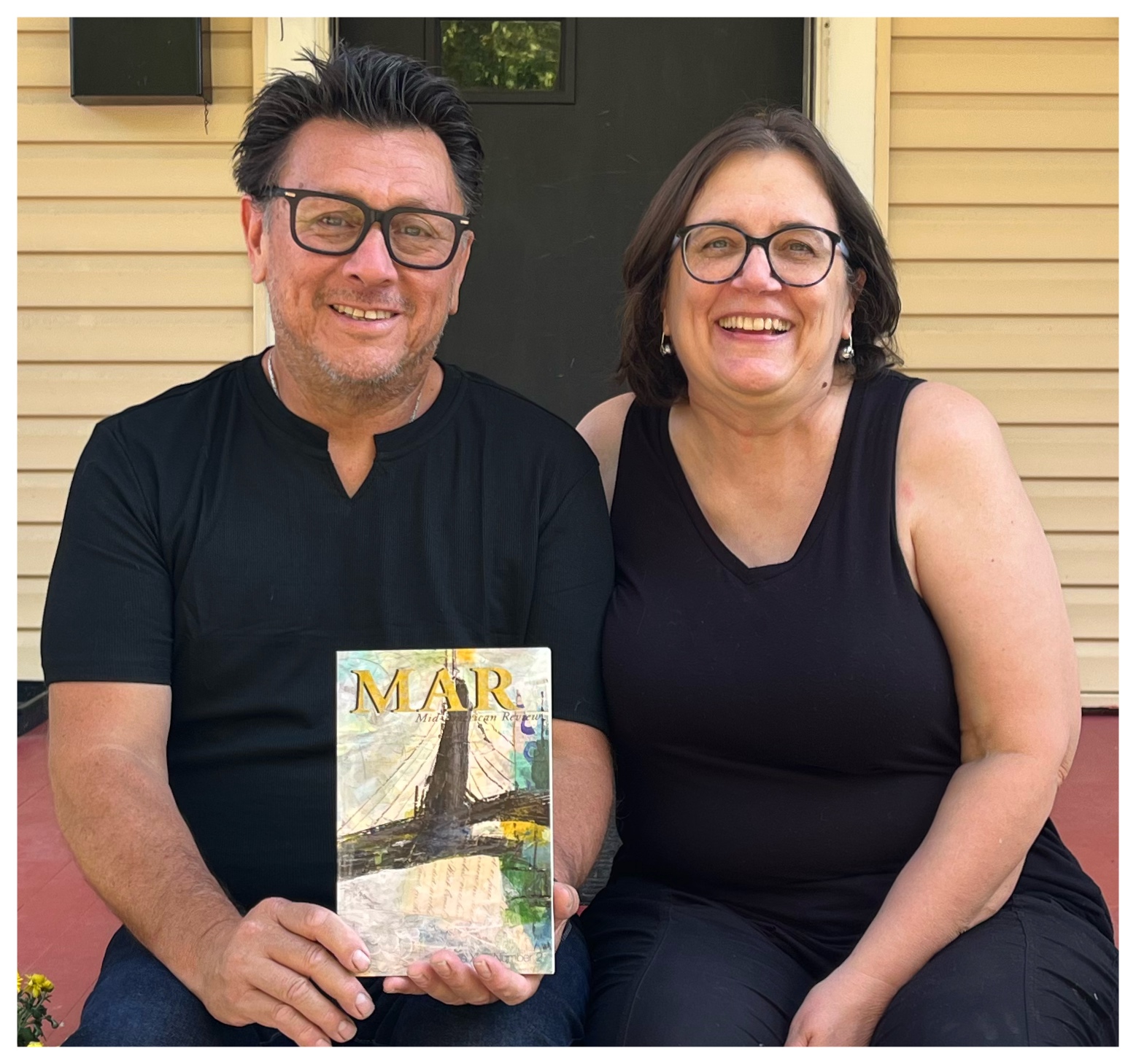 photo of two smiling people, both in black and with glassse