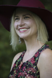 Jennifer Pullen: Smiling blond woman in floral dress and purple hat